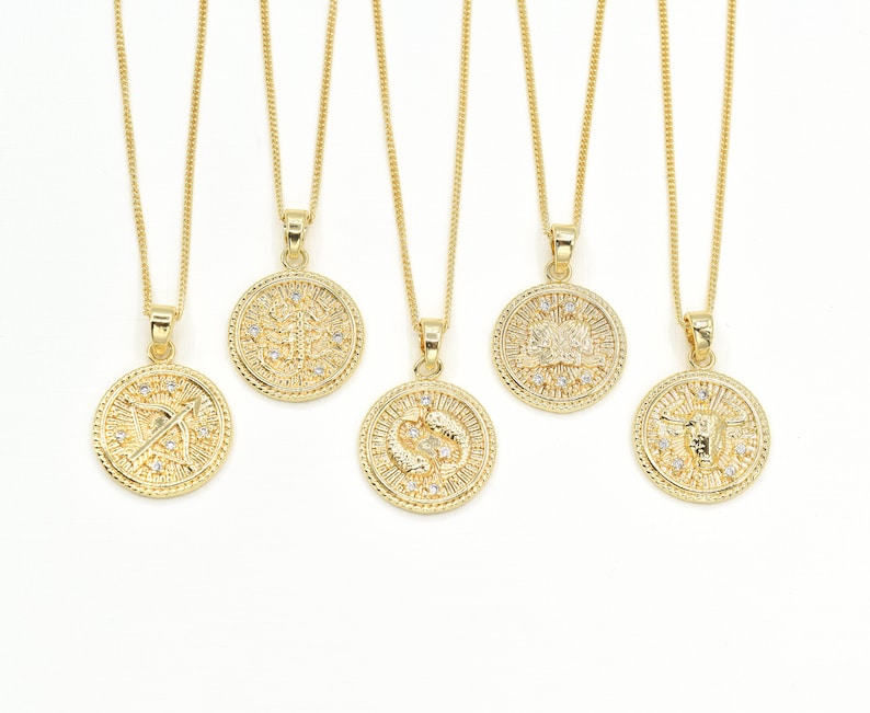May include: Five gold necklaces with zodiac signs on circular pendants. The signs are Sagittarius, Pisces, Taurus, Gemini, and Capricorn.