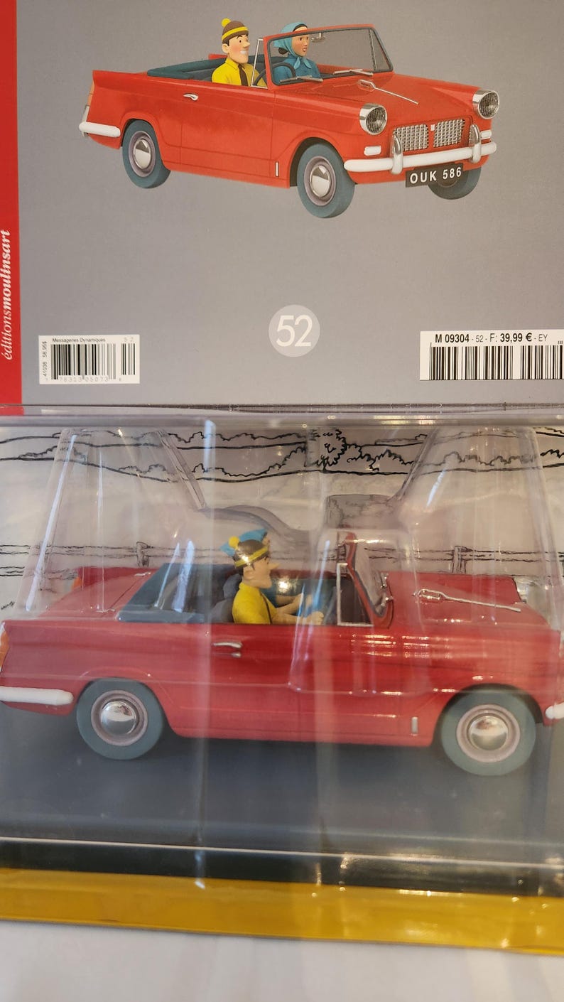 Peut inclure: Une voiture d&eacute;capotable rouge jouet avec deux personnages &agrave; l'int&eacute;rieur. La voiture porte la plaque d'immatriculation "OUK 586". Les personnages portent des chapeaux et ressemblent &agrave; des personnages de dessins anim&eacute;s. La voiture est dans un emballage en plastique transparent.