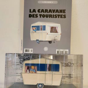 Peut inclure: Une tasse en c&eacute;ramique blanche avec une anse noire et le texte "But First, Coffee" en noir, dans une police manuscrite. La tasse est pos&eacute;e sur une surface blanche.