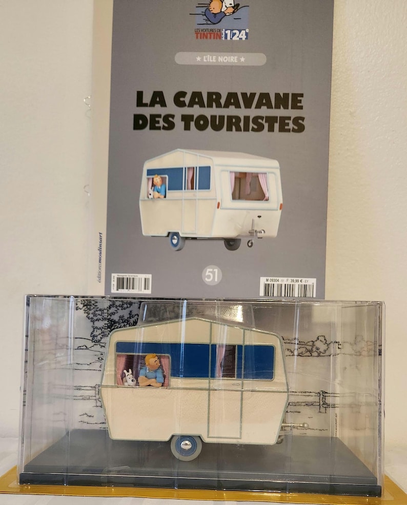 Peut inclure: Une tasse en c&eacute;ramique blanche avec une anse noire et le texte "But First, Coffee" en noir, dans une police manuscrite. La tasse est pos&eacute;e sur une surface blanche.