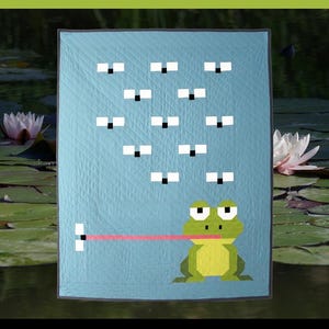 May include: A light blue quilt pattern with a frog design. The quilt measures 40 1/2" x 50 1/2". The quilt features a frog with a long tongue catching flies. The text "WELCOME TO MY PAD" is displayed on the quilt.