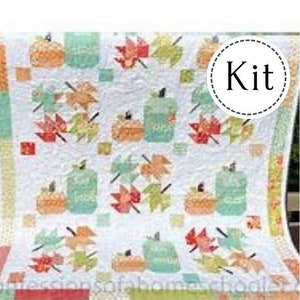 May include: A white quilt kit featuring a repeating pattern of pumpkins and autumn leaves in shades of orange, green, and red. The quilt has a patchwork design with a 'Kit' label.