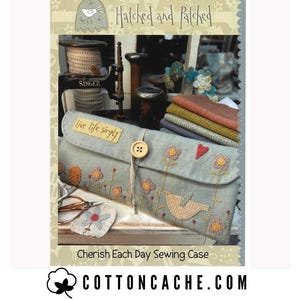 May include: A light blue sewing case with floral and bird embroidery, a wooden button closure, and the text "Cherish Each Day Sewing Case." The case is from "Hatched and Patched" and has the text "live life simply."