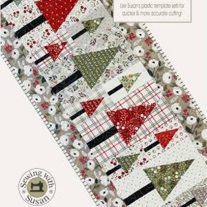 May include: A table runner with a "Fa la la Forest" design featuring a row of stylized Christmas trees in red, green, black, and white fabrics. The runner is 18 1/2 inches by 45 1/2 inches.