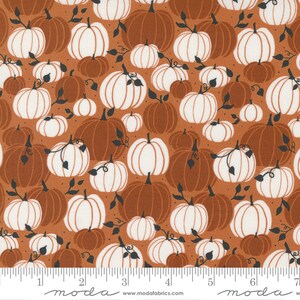May include: A brown fabric with a repeating pattern of white and brown pumpkins. The pumpkins are of various sizes and are arranged in a random pattern. The fabric is perfect for fall crafts and projects.