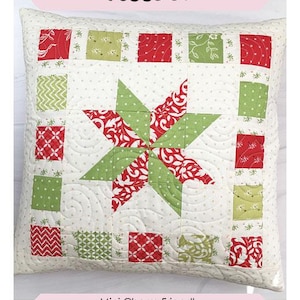 May include: A festive star pillow with a red and green patchwork design. The pillow is 18 inches by 18 inches and is mini charm friendly.
