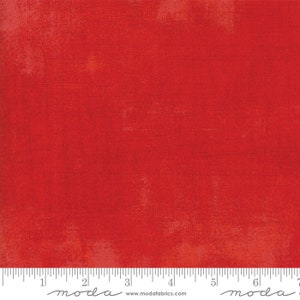 May include: Red fabric with a textured, slightly distressed look. The fabric is a solid color with a subtle variation in the shade of red. The fabric is measured in inches.