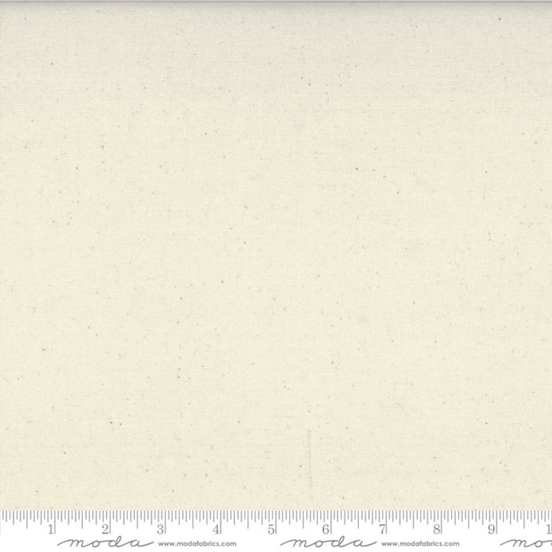 May include: A close-up of a plain, off-white fabric with a subtle speckled texture. The fabric is a natural color with a slightly rough surface.