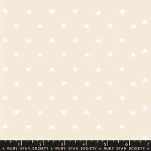 May include: A seamless pattern featuring a repeating design of small white hearts on a light beige background.