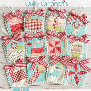 May include: Twelve quilted Christmas ornaments in various patterns and colors, including red, white, and blue. The ornaments are tied with red and white ribbon and have a white pom-pom trim. The ornaments are arranged on a wooden surface. The text "2023 Sew Jolly Quilty Ornaments" is at the top of the image.