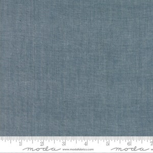 May include: A close-up of a blue fabric with a textured weave. The fabric is measured with a ruler that reads "moda" and "www.modafabrics.com".