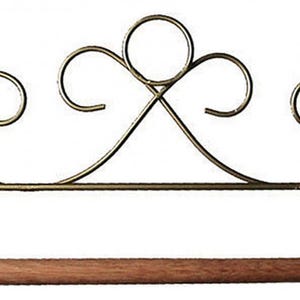 May include: A decorative paper towel holder with a scrolled metal design in a gold finish. The holder features a wooden dowel for the paper towels. The top has a decorative swirl design.