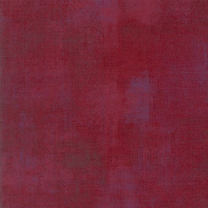 May include: A solid red fabric with a subtle textured pattern. The fabric has a slightly distressed look, with faded areas and a hint of blue.