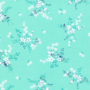 May include: A turquoise fabric with a white floral pattern. The flowers are small and delicate, and they are arranged in clusters throughout the fabric.