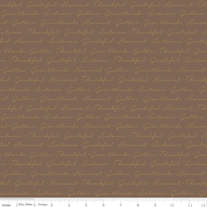 May include: A brown fabric with a gold-colored pattern of the words "Thankful", "Grateful", "Harvest", "Autumn", and "Give thanks" repeated in a seamless pattern.