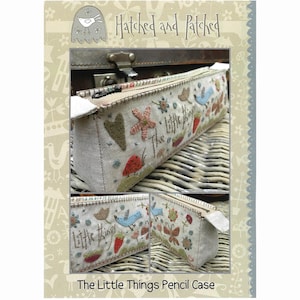 May include: A beige pencil case with a zipper closure. The case is decorated with colorful embroidered flowers, birds, and the text "The Little Things".