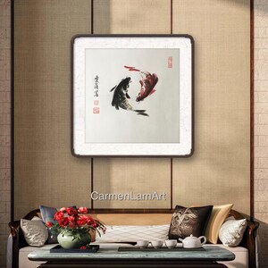 May include: A framed artwork featuring two koi fish in a traditional Asian ink painting style. One fish is black, the other red, swimming in opposite directions. The artwork is set against a neutral background.