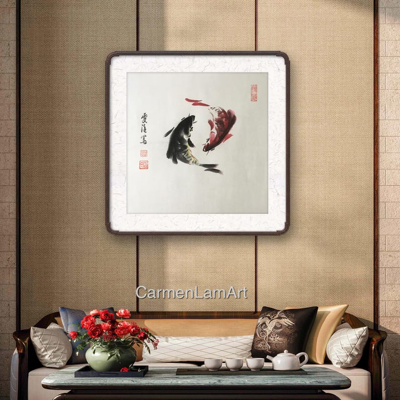 May include: A framed artwork featuring two koi fish in a traditional Asian ink painting style. One fish is black, the other red, swimming in opposite directions. The artwork is set against a neutral background.