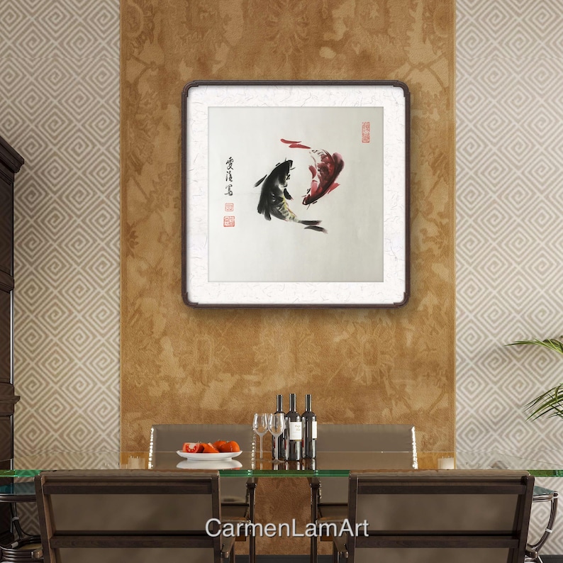 May include: A framed artwork featuring a traditional Asian ink painting of two koi fish. One fish is black, the other is red, and they are depicted swimming in opposite directions. The artwork is displayed on a textured wall.