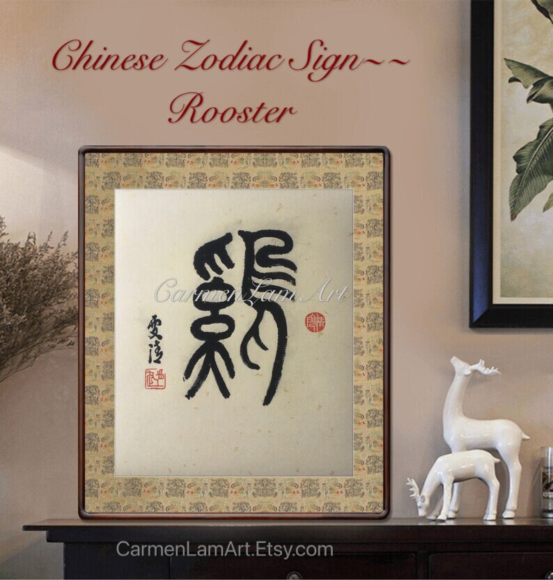 Puede incluir: Una pintura china de caligraf&iacute;a enmarcada del signo del zod&iacute;aco chino del Gallo. La pintura est&aacute; sobre un fondo crema con tinta negra. Los caracteres chinos para Gallo est&aacute;n escritos en tinta negra. La pintura est&aacute; enmarcada en un marco de madera oscura con un borde dorado.