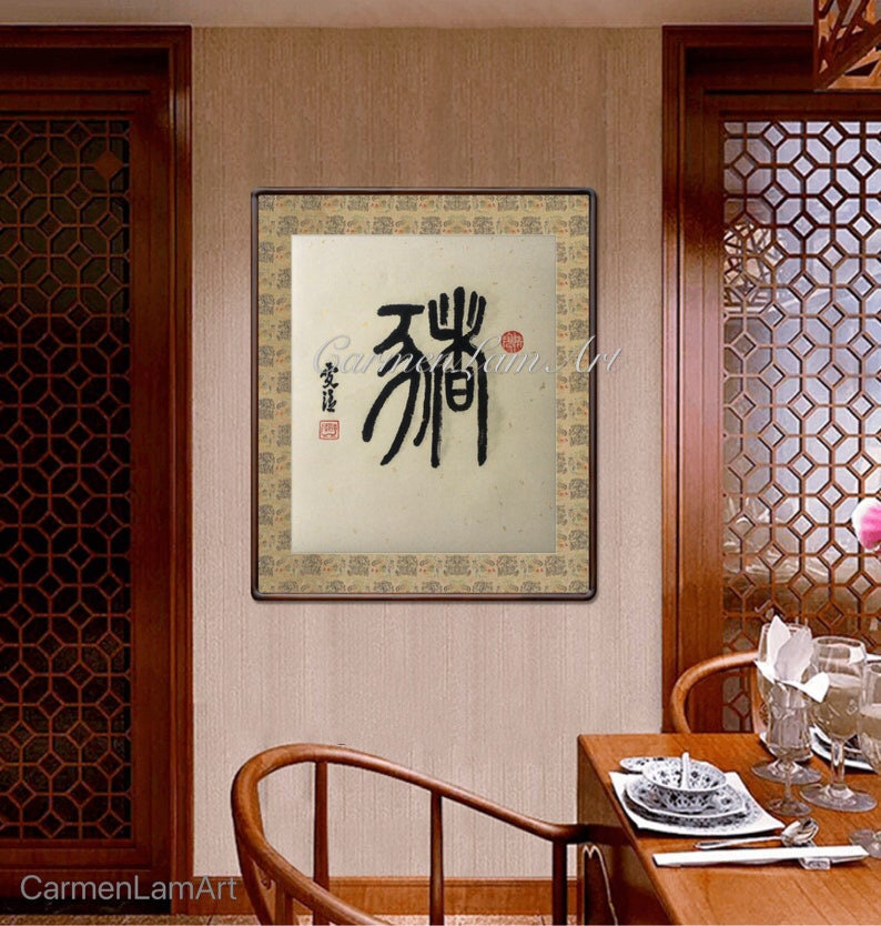 Puede incluir: Una obra de arte de caligraf&iacute;a enmarcada con tinta negra sobre un fondo beige. La obra est&aacute; en un marco de madera con un borde decorativo. La caligraf&iacute;a dice "天翔".