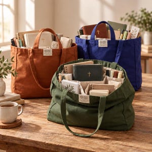 May include: Three canvas tote bags in rust, blue, and olive green, each featuring internal dividers and a small rectangular label with the text OIKO FONI. The bags are filled with various notebooks, pens, and small pouches.