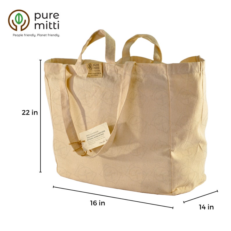 May include: A large, beige canvas tote bag with two handles. The bag is 22 inches tall, 16 inches wide, and 14 inches deep. The bag has a small brown tag attached to one of the handles that says "Pure Mitti" and "This product is hand made by skilled workers in India".