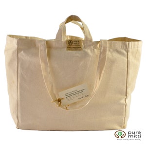 May include: A natural beige canvas tote bag with a brown label that reads "pure mitti" and "Know your producer. This product is handmade by rural women in India."