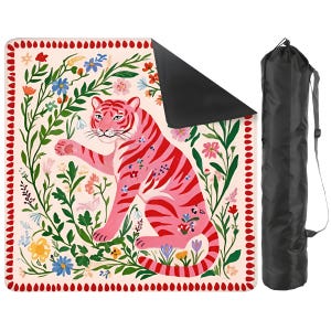 May include: A square outdoor blanket featuring a pink tiger surrounded by colourful floral illustrations on a cream background with a red border, accompanied by a black cylindrical carrying bag with an adjustable shoulder strap.