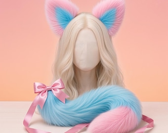 May include: A set of cosplay accessories featuring a pair of pink and blue fox ears and a matching tail. The ears are pink with blue inner details. The tail is blue with a pink tip and a pink ribbon.
