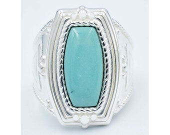 Puede incluir: Un anillo de plata con una piedra turquesa rectangular. El anillo tiene un diseño decorativo alrededor de la piedra y en la banda. La piedra turquesa es de color azul verdoso claro. El anillo está sobre un fondo blanco.