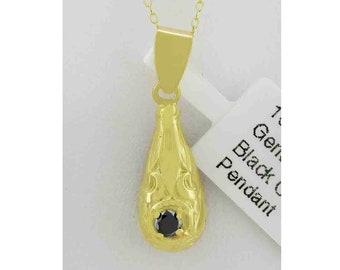 May include: A gold pendant necklace with a teardrop-shaped pendant featuring a black gemstone. The pendant has an ornate design.