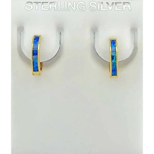 May include: Gold-coloured hoop earrings, each with a rectangular inlay of blue and teal stones. The earrings are displayed on a white background with the text "STERLING SILVER" at the top.