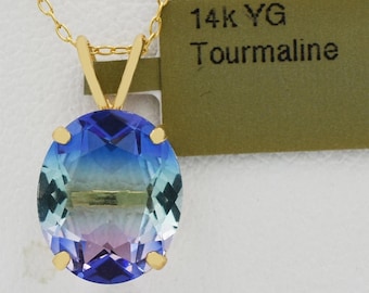 May include: A gold necklace with a large, oval-shaped tourmaline pendant. The gemstone displays a gradient of colors, transitioning from blue to purple. The tag reads "14k YG Tourmaline".