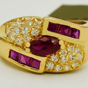 May include: A gold ring with a large oval ruby surrounded by smaller rubies and diamonds.
