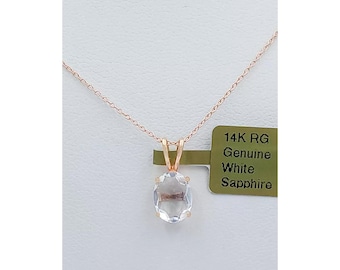 May include: A 14K rose gold necklace with a genuine white sapphire pendant. The pendant is oval shaped and has a clear, faceted stone. The tag reads "14K RG Genuine White Sapphire".