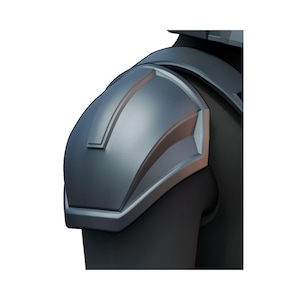 May include: A close-up of a metallic gray shoulder armor piece. The armor has a curved design with raised edges and a brushed metal texture. The shoulder armor is attached to a black garment.