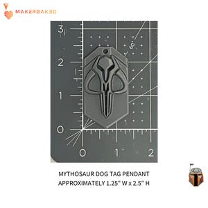 May include: A gray Mythosaur dog tag pendant, approximately 1.25 inches wide and 2.5 inches high. The tag features a detailed design of the Mythosaur skull. The tag is shown on a black grid background.