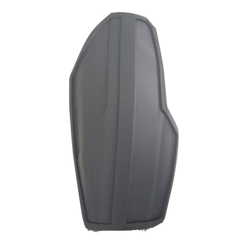 Pu&ograve; includere: Un oggetto grigio a forma di scudo con creste verticali e un bordo curvo. L'oggetto ha una finitura liscia e opaca e sembra essere fatto di un materiale solido. Il design &egrave; simmetrico, con una linea verticale centrale e un lato leggermente angolato.