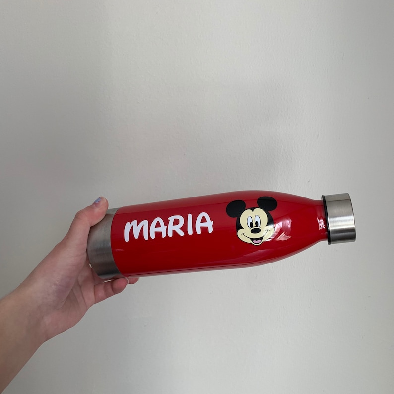 K&ouml;nnte beinhalten: Rote Edelstahl-Wasserflasche mit einem wei&szlig;en Mickey-Maus-Gesicht und dem Namen "MARIA" auf der Seite.