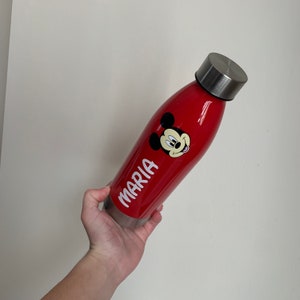 K&ouml;nnte beinhalten: Rote Wasserflasche mit Mickey-Maus-Motiv und dem Namen "MARIA" auf der Seite.