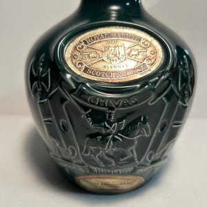 May include: A green ceramic bottle with a gold label that reads "Chivas Regal Salute 21 Years Old Blended Scotch Whisky".