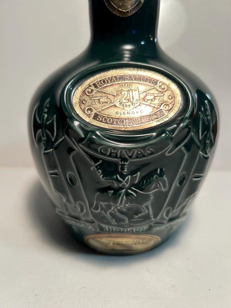 May include: A green ceramic bottle with a gold label that reads "Chivas Regal Salute 21 Years Old Blended Scotch Whisky".