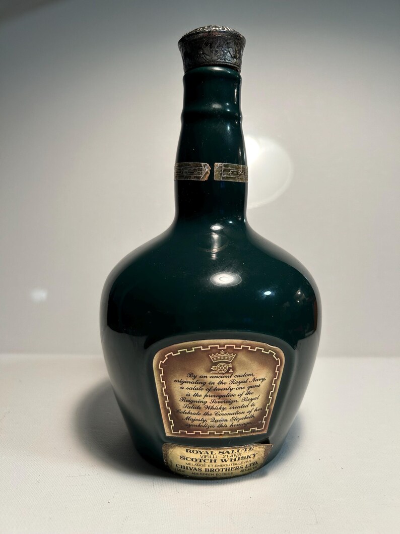 May include: A dark green glass bottle of Royal Salute Scotch Whisky. The bottle has a gold label with the text "Royal Salute Scotch Whisky" and "Chivas Brothers Ltd."