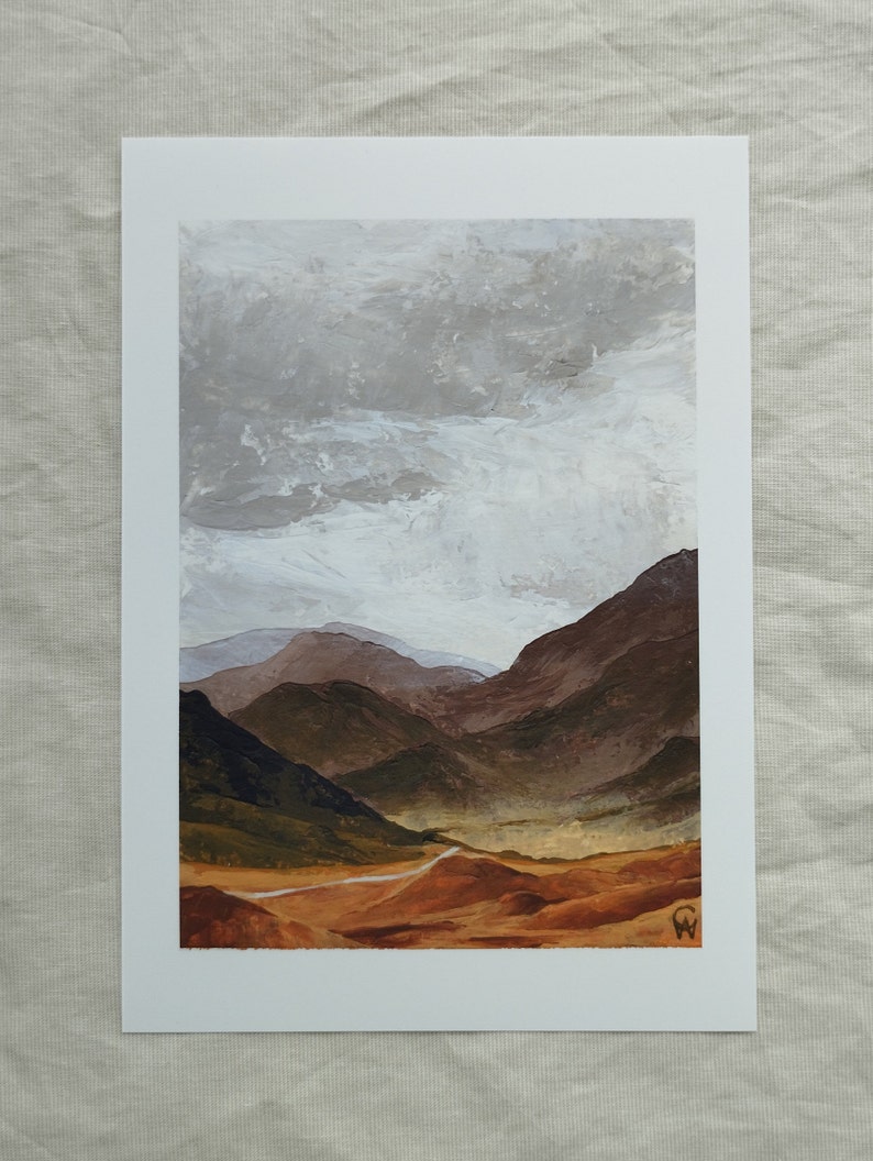 Art print of a neutral painting on paper of a textured cloudy sky behind warm beige and brown hilly mountains with a lone road running through