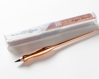 Könnte beinhalten: Ein schräger Bleistift in Roségold mit einem transparenten Kunststoffetui. Das Etui trägt ein Etikett mit der Aufschrift "Copper Sunrise". Der Bleistift ist ein Schreibwerkzeug für Künstler und Kalligraphen.