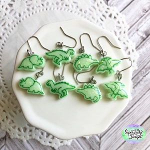 Brincos de dinossauro pendurados em resina verde que brilha no escuro - brincos de resina - Brincos Dino