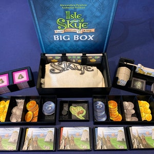 May include: A black organizer insert for the Isle of Skye: From Catan to King Big Box board game. The insert includes compartments for the game's components, including cards, tokens, and a cloth bag. The insert is made of black plastic and has a grid pattern.