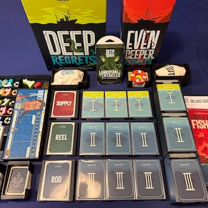Può includere: Un gioco da tavolo con i titoli "Deep Regrets" e "Even Deeper Regrets" sulle scatole. Il gioco include carte, pedine e una piccola scatola con l'etichetta "Lamentable Tentacles". Il gioco ha un tema di pesca.