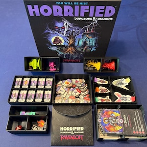 May include: A Horrified Dungeons & Dragons Ravenloft board game set featuring a large game box, black plastic storage trays, miniature figures in neon green and red, various character cards, small cardboard tokens, and a deck of game cards.